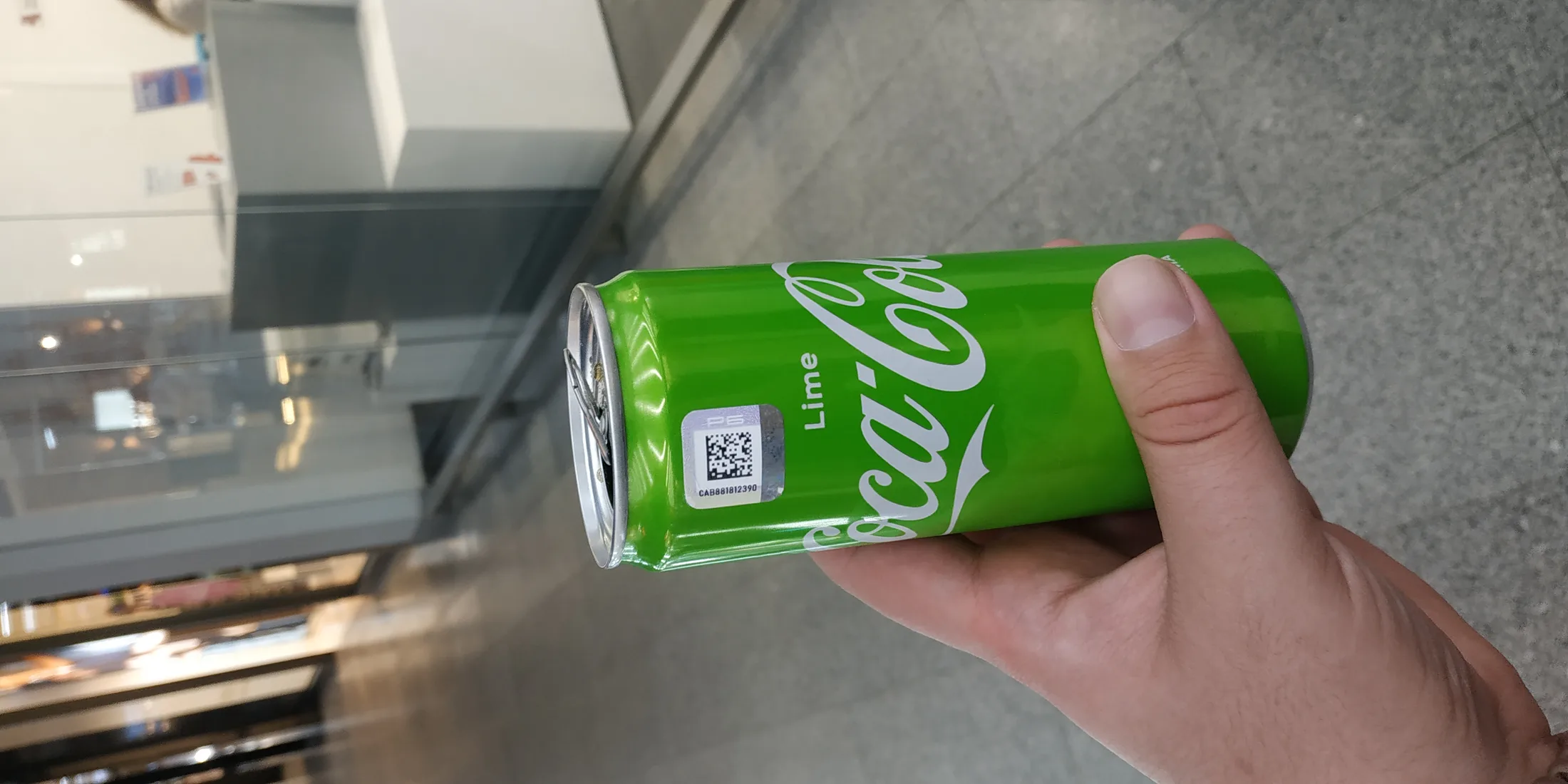Зелёная банка Coca-Cola Lime в руке