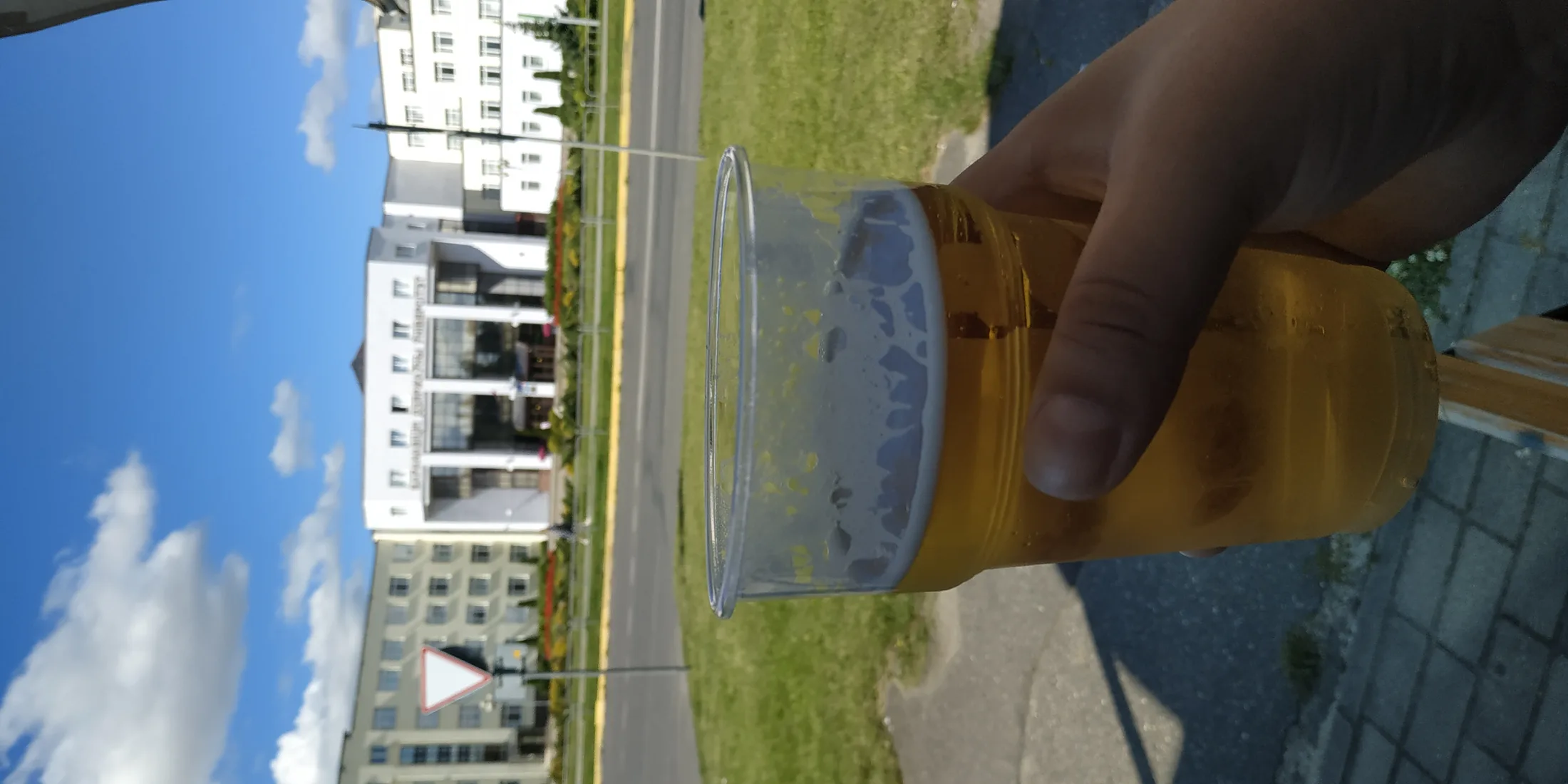 Пиво в пластике на фоне здания БарГУ, синее небо