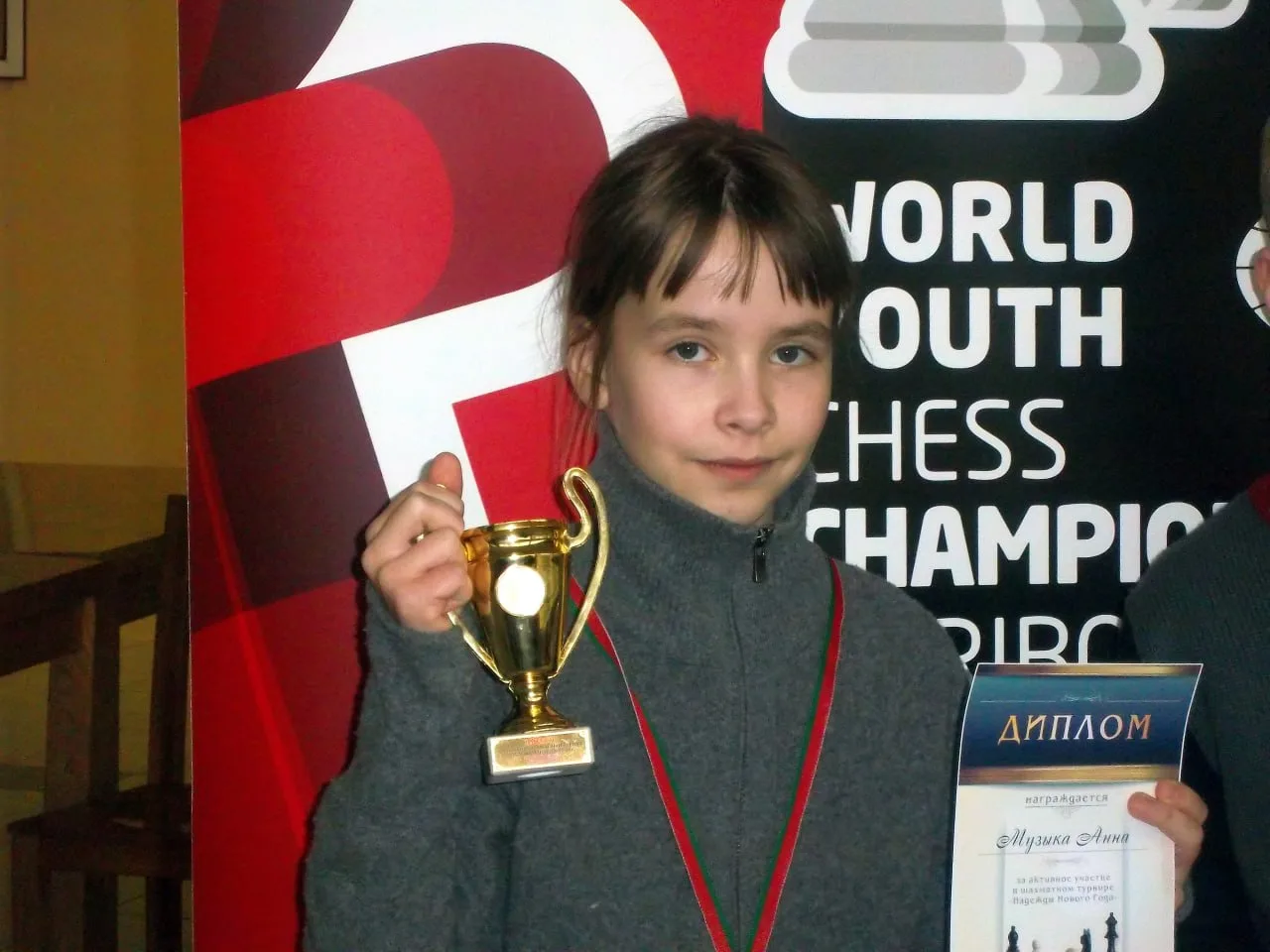 Девочка с кубком и дипломом World Youth Chess Championship